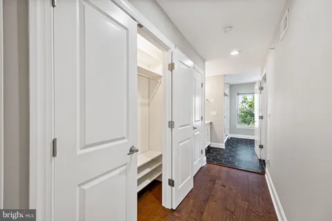 a view of an empty room with wooden floor and stairs
