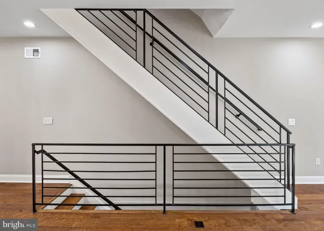 a kitchen with granite countertop a stove top oven a sink dishwasher a refrigerator and white cabinets with wooden floor