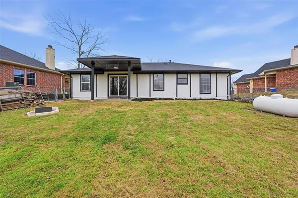 a front view of a house with a garden and trees