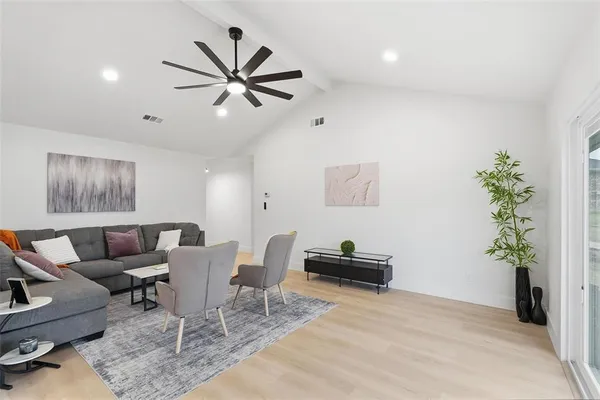 a living room with furniture a window and a potted plant