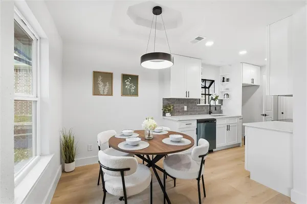 a kitchen with a table chairs stove and white cabinets