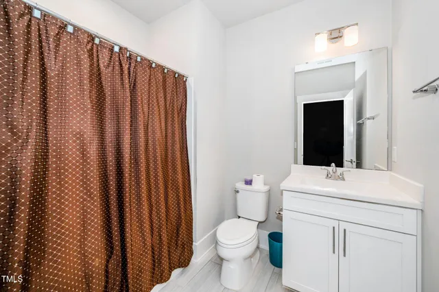 a bathroom with a sink a toilet and shower curtain
