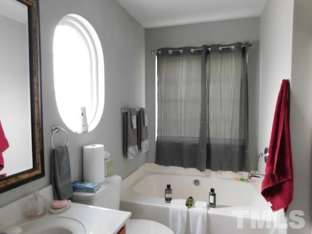 924 Roxy Street Raleigh, NC 27610 - Photo 13 of 15 a bathroom with a tub sink and a mirror