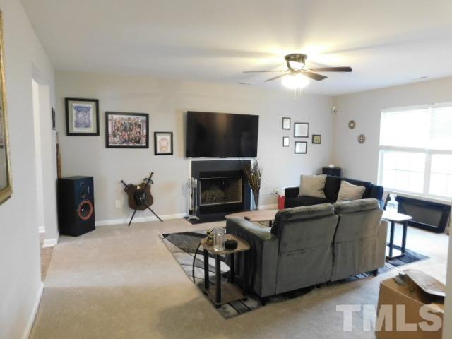 924 Roxy Street Raleigh, NC 27610 - Photo 3 of 15 a living room with furniture a flat screen tv and a fireplace
