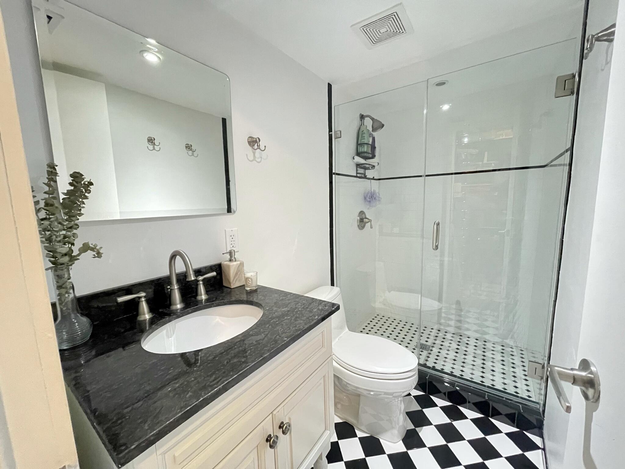 3258 Virginia Street, Unit A4 Miami, FL 33133 - Photo 12 of 20 a bathroom with a sink toilet a mirror and shower