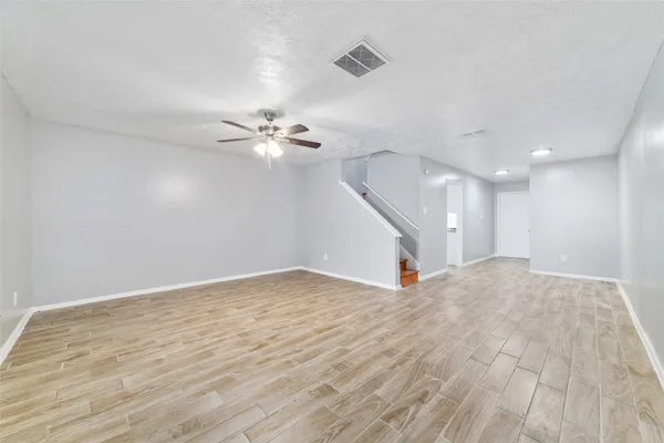 a view of empty room with wooden floor