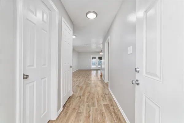 a view of a hallway with wooden floor