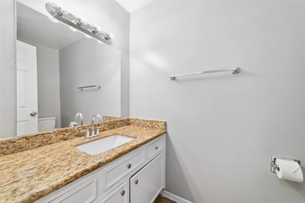 a bathroom with a granite countertop sink and a mirror