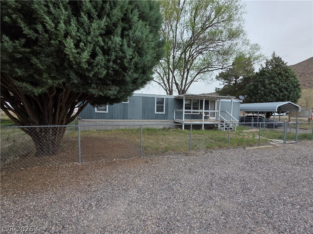 101 Ada Street, Unit 12 Caliente, NV 89008 - Photo 13 of 14 A well-maintained home awaits, featuring a covered porch and gravel driveway for convenient parking.