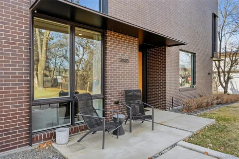 a porch with a bench and chairs