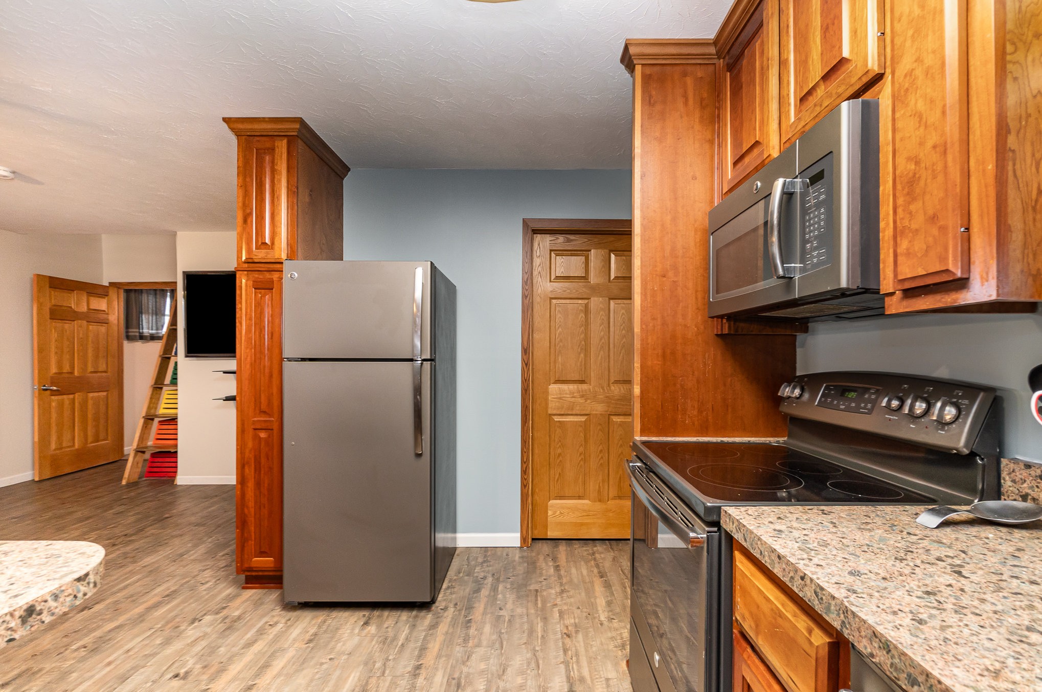 6960 Highway 231 Bethpage, TN 37022 - Photo 9 of 32 a kitchen with stainless steel appliances granite countertop a refrigerator a stove and a wooden floors