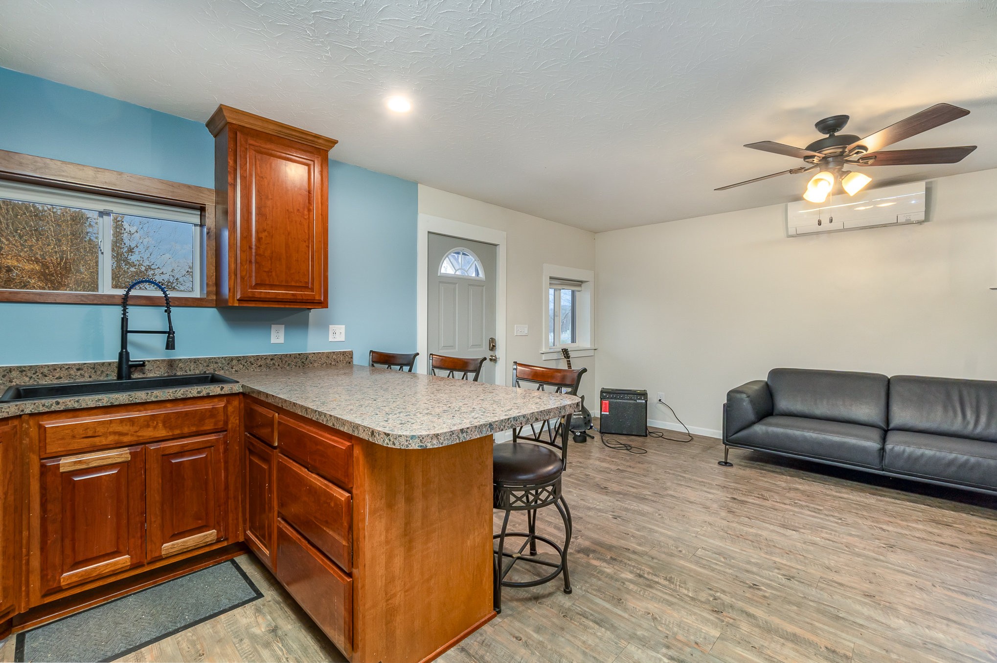 6960 Highway 231 Bethpage, TN 37022 - Photo 10 of 32 a kitchen with stainless steel appliances granite countertop a sink a stove top oven a chimney cabinets and wooden floor