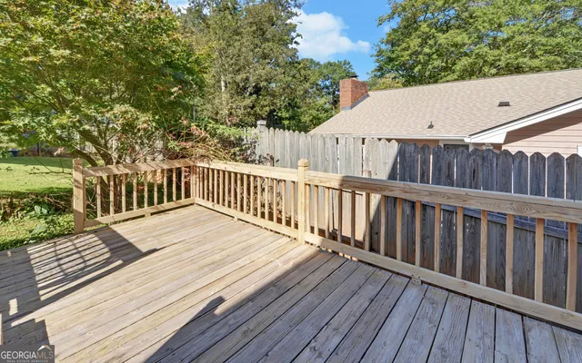 a view of a house with patio and wooden fence
