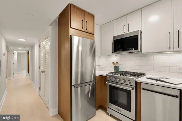 a kitchen with stainless steel appliances a refrigerator stove and microwave