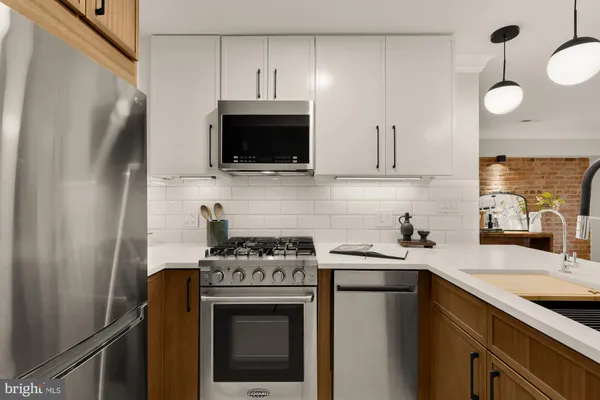 a kitchen with stainless steel appliances a stove a sink and a microwave