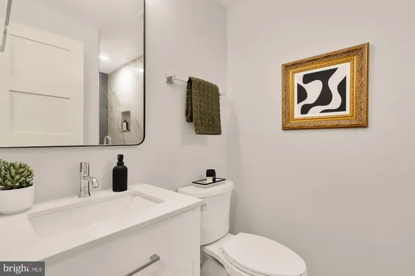 a bathroom with a toilet sink and mirror