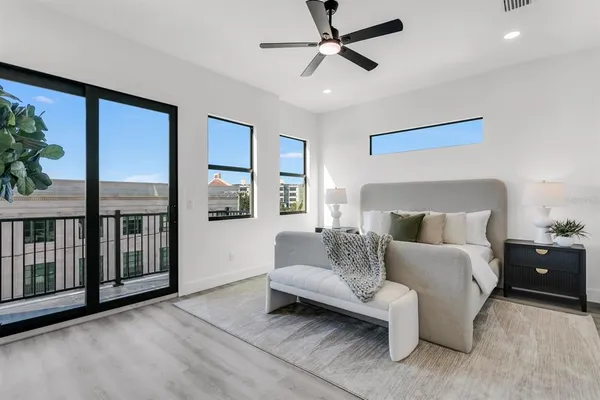 a spacious bedroom with a bed couch and a large window