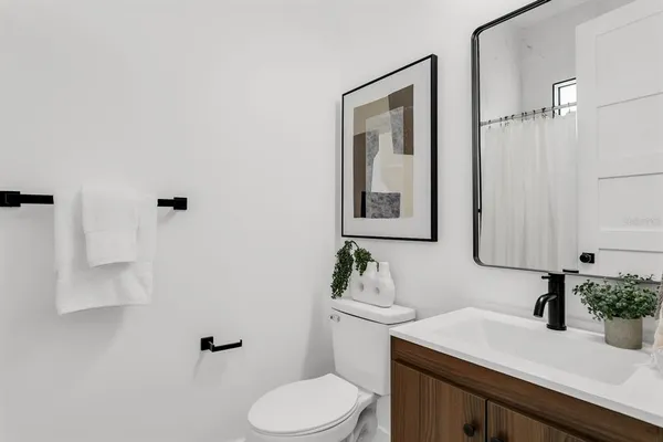 a bathroom with a granite countertop sink mirror and toilet