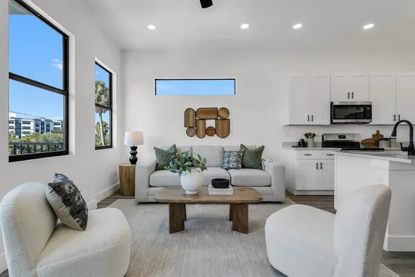 a living room with furniture a rug and a painting on the wall