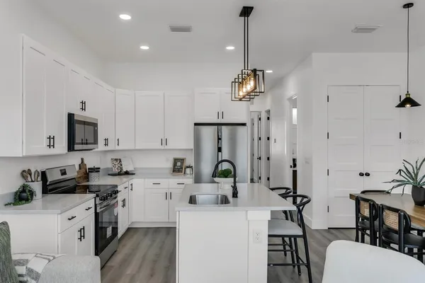 a kitchen with stainless steel appliances kitchen island granite countertop a sink a stove a refrigerator and cabinets