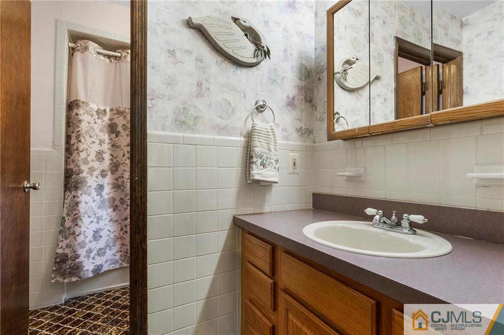 23 Roxy Avenue Edison, NJ 08820 - Photo 14 of 24 a bathroom with a sink and a mirror