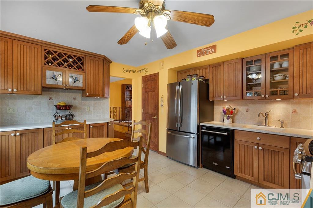 23 Roxy Avenue Edison, NJ 08820 - Photo 3 of 24 a kitchen with stainless steel appliances granite countertop a refrigerator a sink a stove a dining table and chairs with wooden floor