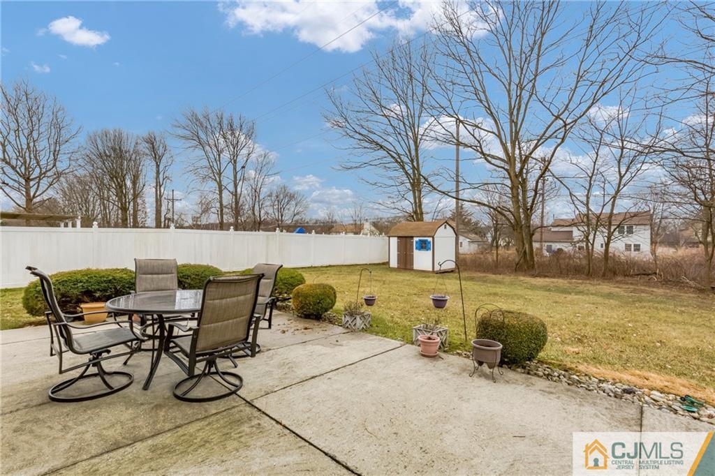 23 Roxy Avenue Edison, NJ 08820 - Photo 23 of 24 a view of a backyard with table and chairs under an umbrella