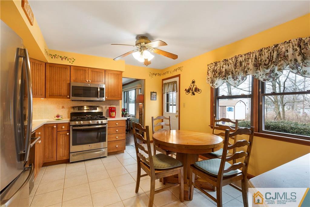 23 Roxy Avenue Edison, NJ 08820 - Photo 7 of 24 a kitchen with stainless steel appliances kitchen island granite countertop a table chairs microwave and sink