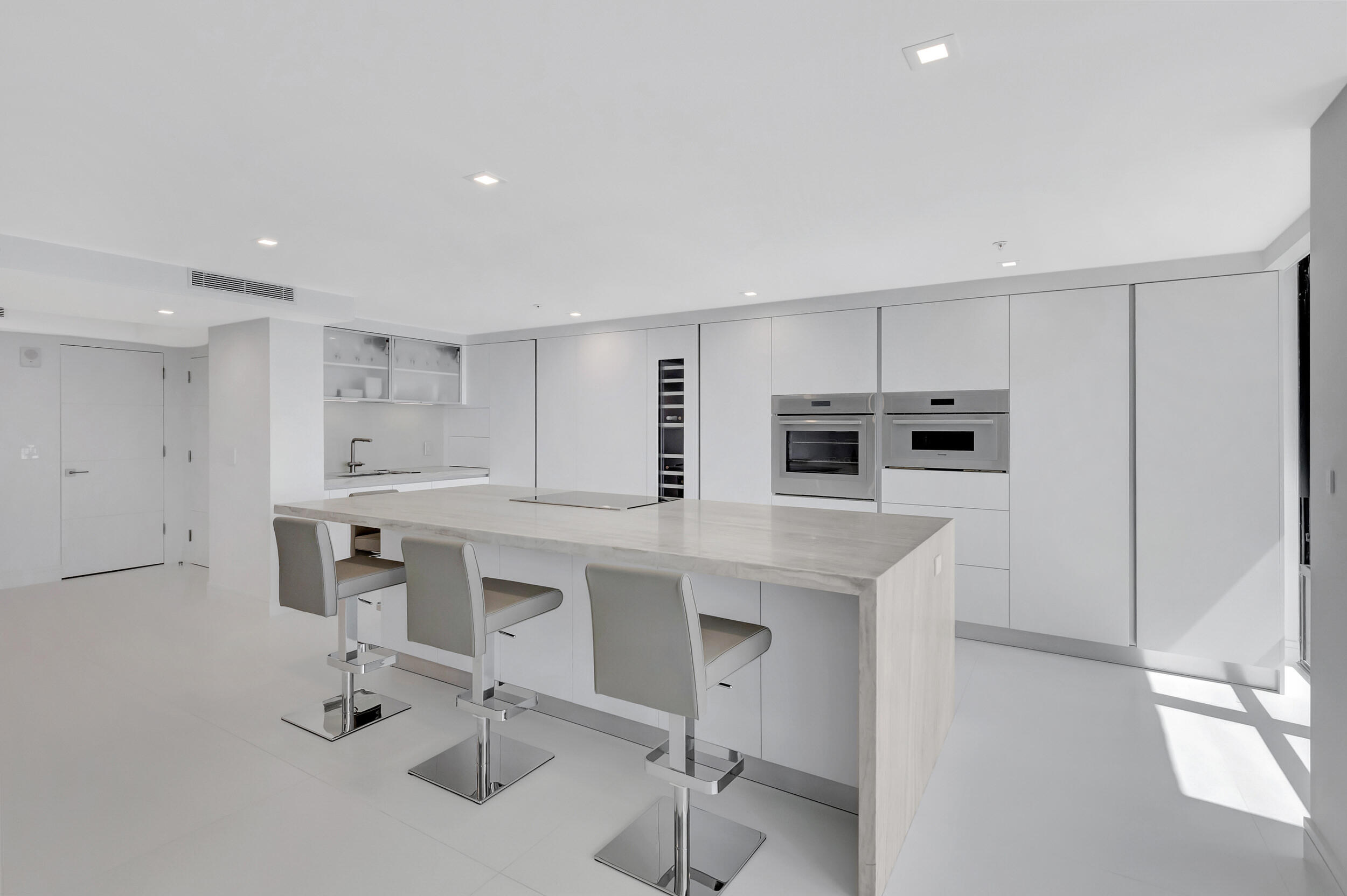 250 South Ocean Boulevard, Unit 16G Boca Raton, FL 33432 - Photo 23 of 91 a kitchen with kitchen island a sink table and chairs