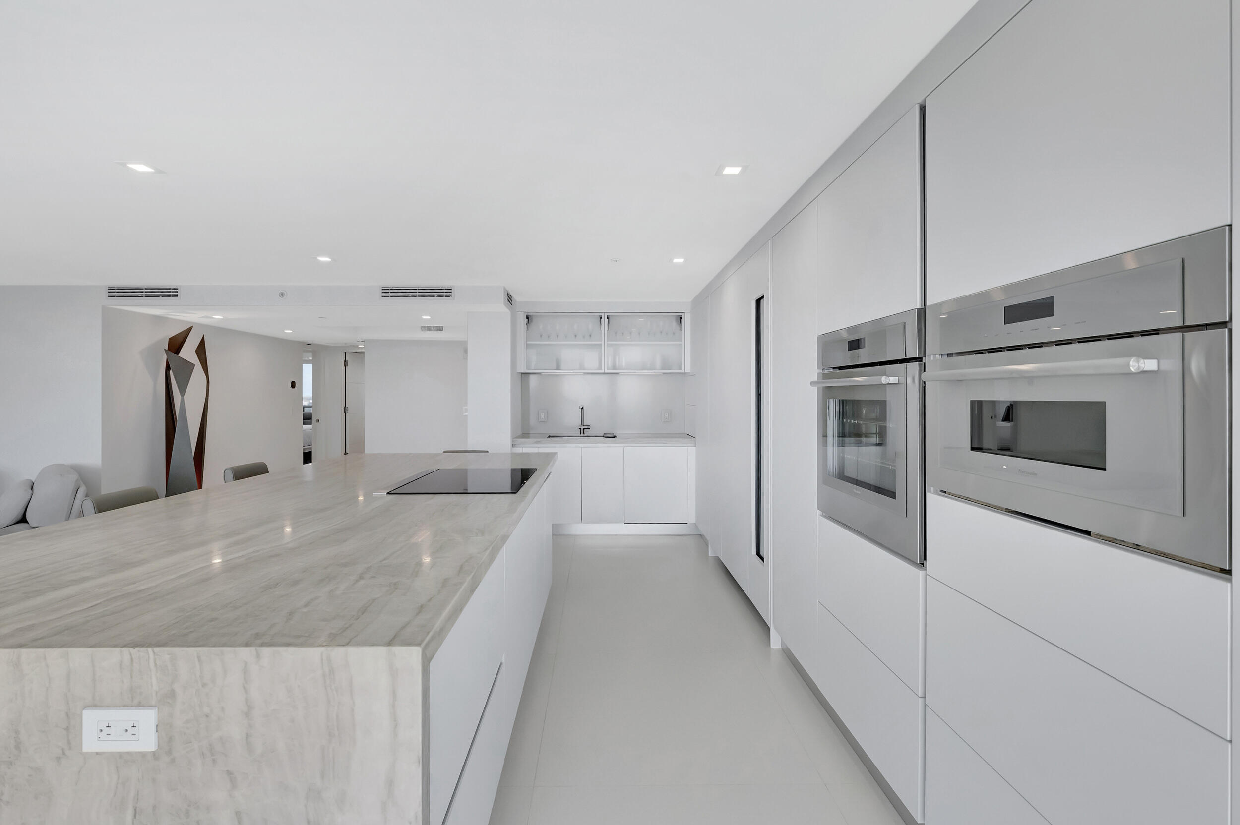 250 South Ocean Boulevard, Unit 16G Boca Raton, FL 33432 - Photo 25 of 91 a large white kitchen with kitchen island a sink stainless steel appliances and cabinets