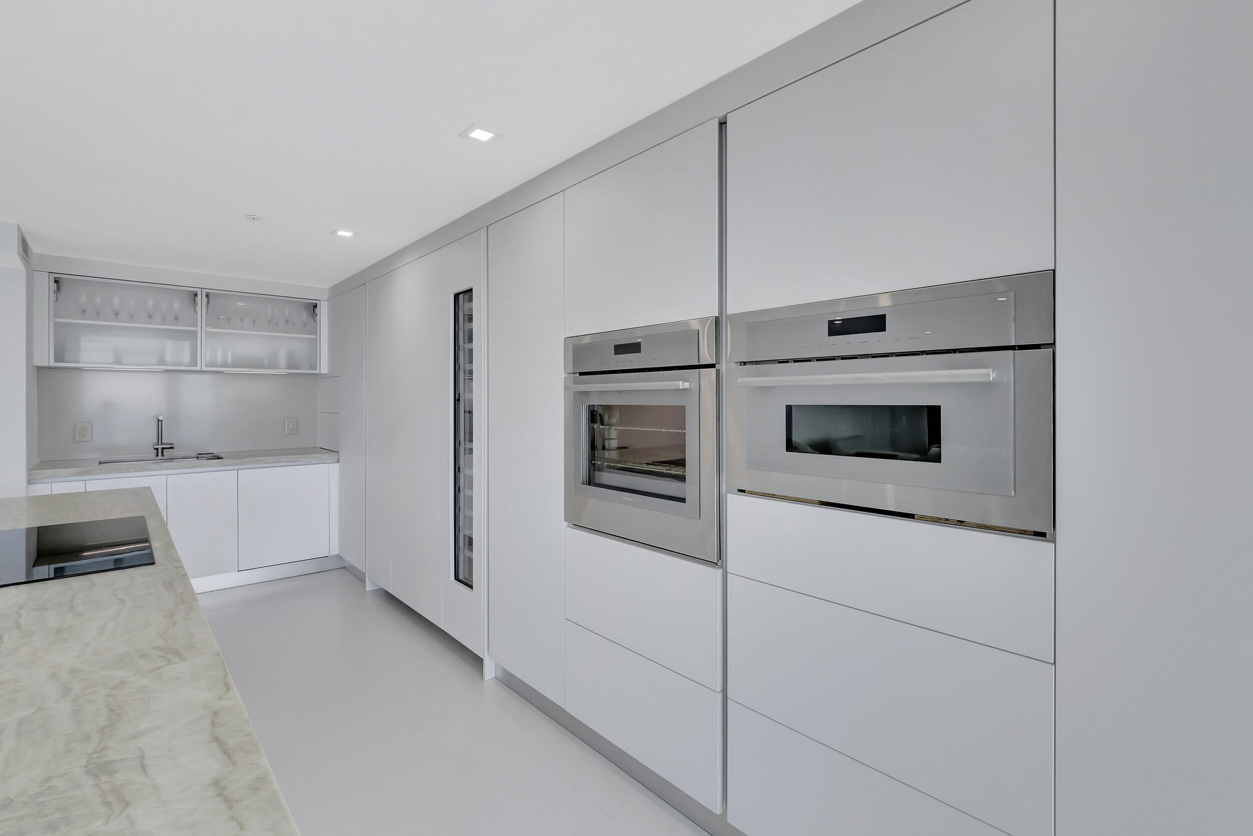 250 South Ocean Boulevard, Unit 16G Boca Raton, FL 33432 - Photo 26 of 91 a kitchen with stainless steel appliances white cabinets and a refrigerator