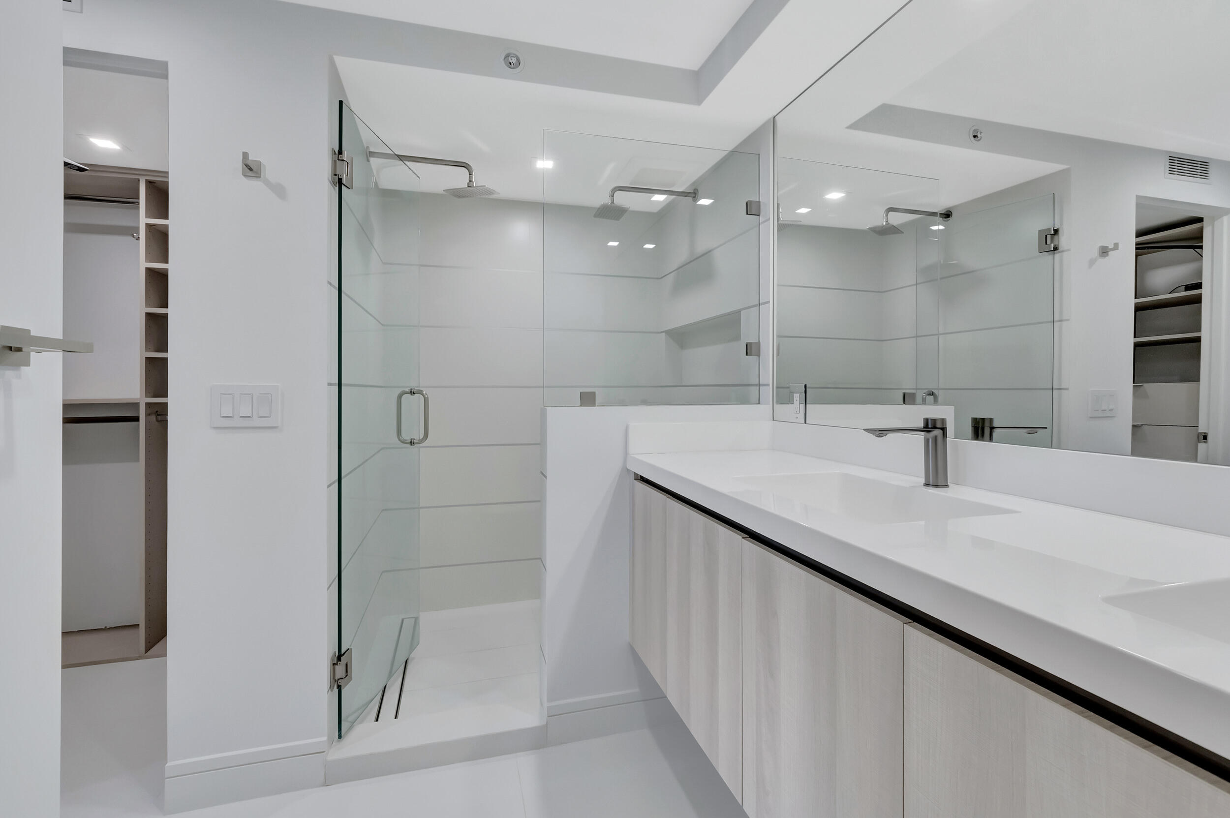 250 South Ocean Boulevard, Unit 16G Boca Raton, FL 33432 - Photo 50 of 91 a bathroom with a double vanity sink mirror and shower