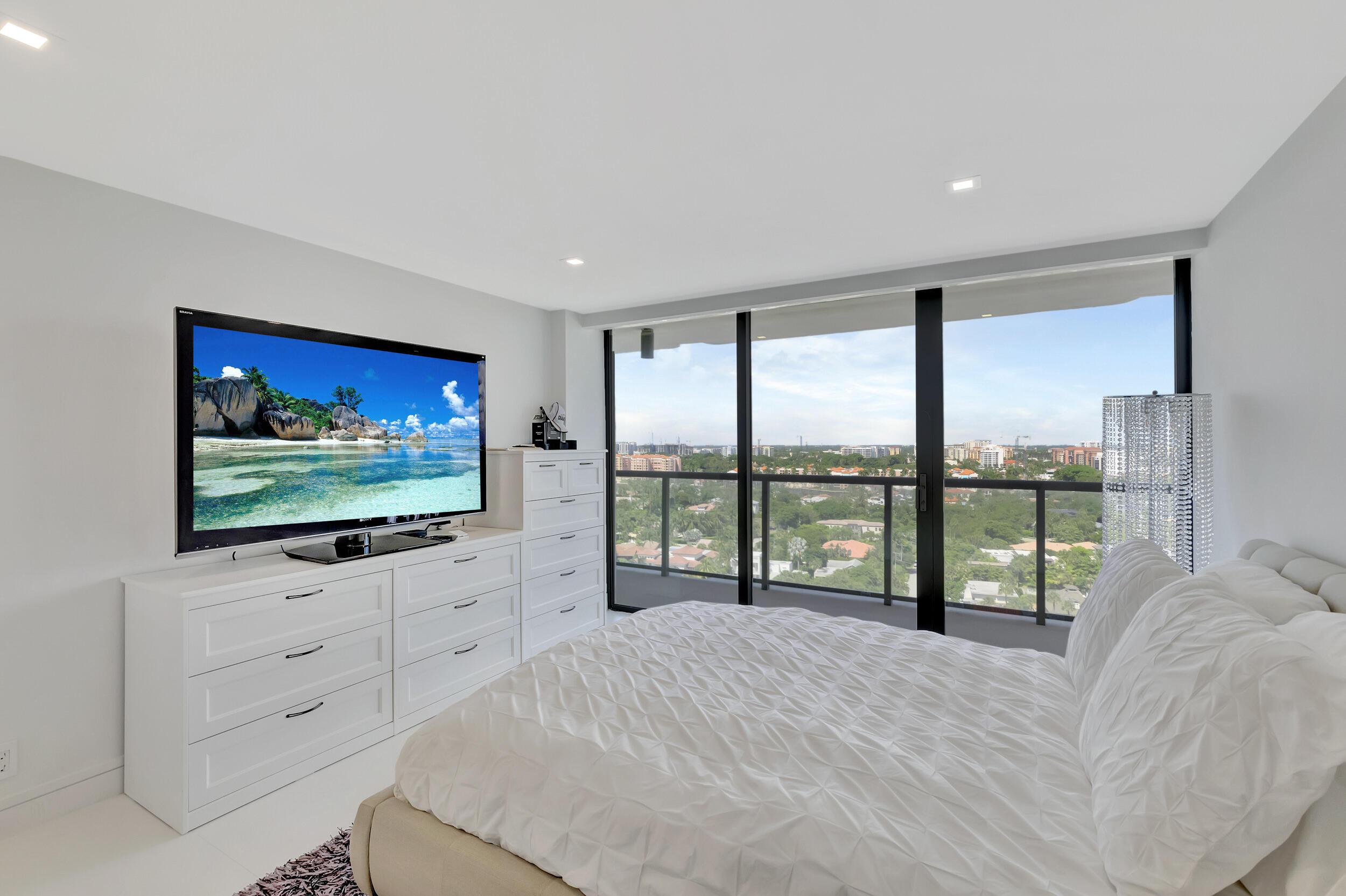 250 South Ocean Boulevard, Unit 16G Boca Raton, FL 33432 - Photo 57 of 91 a living room with flat screen tv and a floor to ceiling window