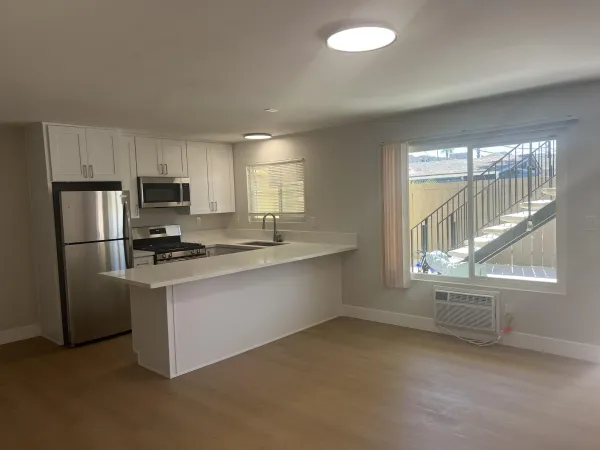 a kitchen with granite countertop a refrigerator and a stove top oven