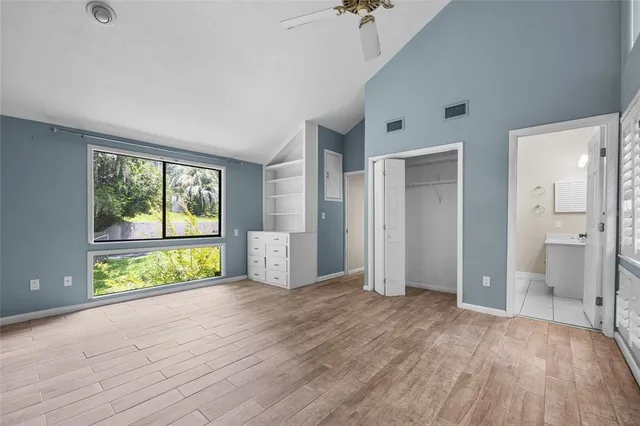 a view of empty room with wooden floor and fan