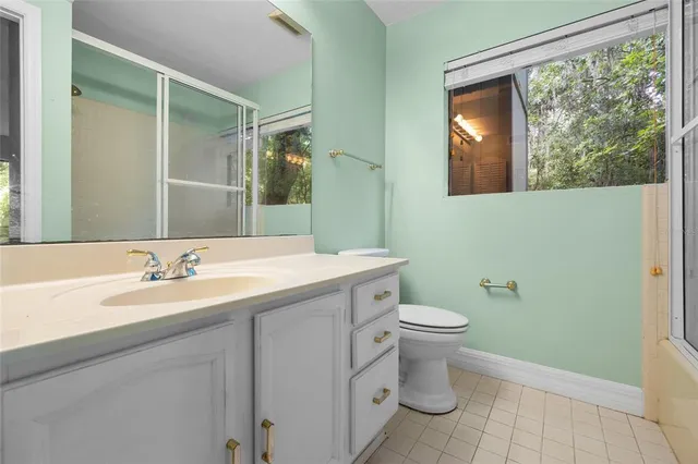 a bathroom with a granite countertop sink toilet and a mirror