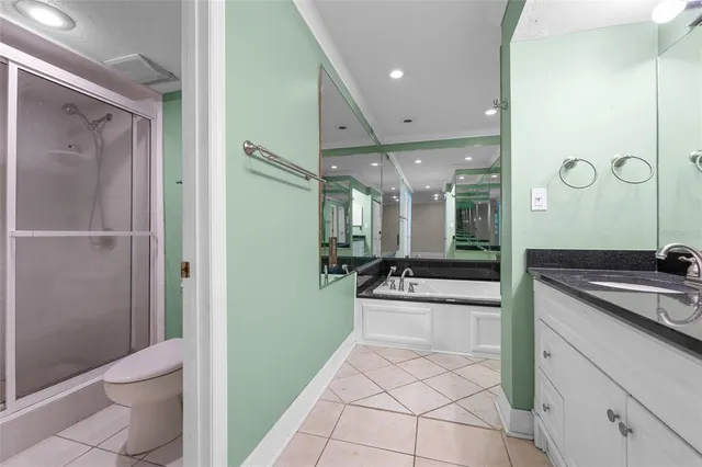a large bathroom with a granite countertop sink a toilet a mirror and shower