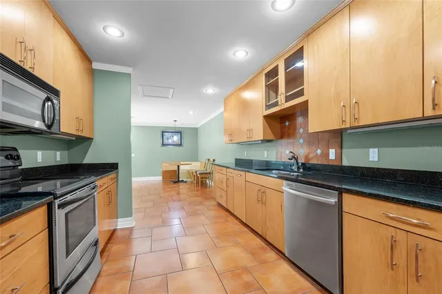 a kitchen with stainless steel appliances granite countertop a stove a sink and a microwave
