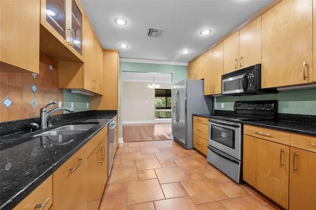 a large kitchen with stainless steel appliances granite countertop a stove and a sink