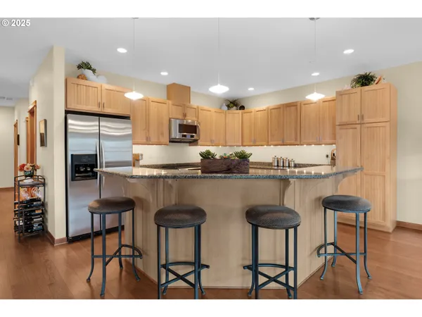 a kitchen with kitchen island granite countertop wooden cabinets and a refrigerator