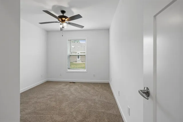an empty room with chandelier fan
