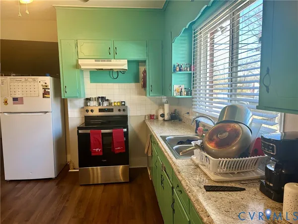 a kitchen with a refrigerator and a stove top oven