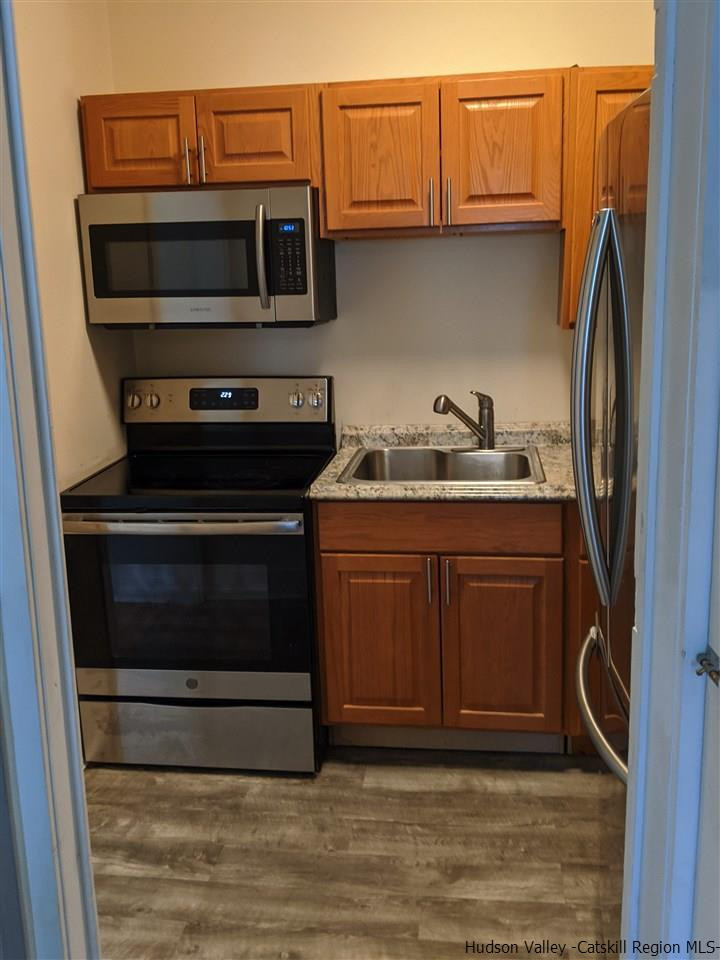 78-88 Spring Street Kingston, NY 12401 - Photo 26 of 34 a kitchen with stainless steel appliances a stove a microwave and sink
