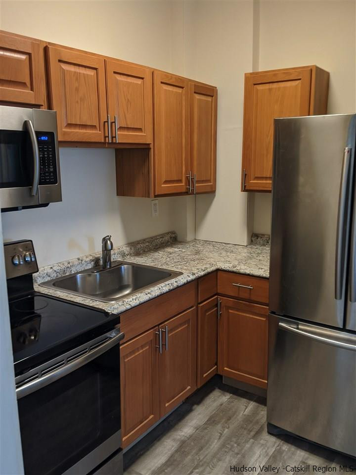 78-88 Spring Street Kingston, NY 12401 - Photo 27 of 34 a kitchen with granite countertop stainless steel appliances and wooden cabinets