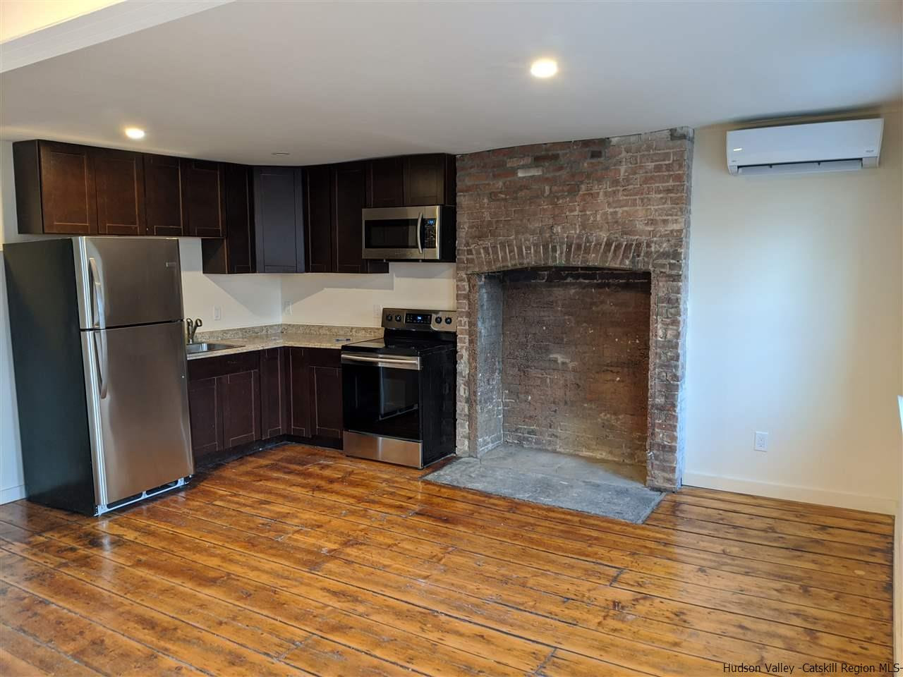 78-88 Spring Street Kingston, NY 12401 - Photo 9 of 34 a kitchen with stainless steel appliances granite countertop a refrigerator and a wooden floor