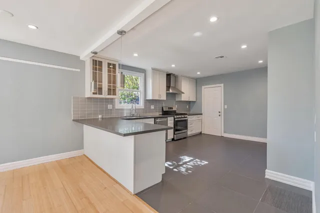a kitchen with stainless steel appliances granite countertop a sink stove and cabinets