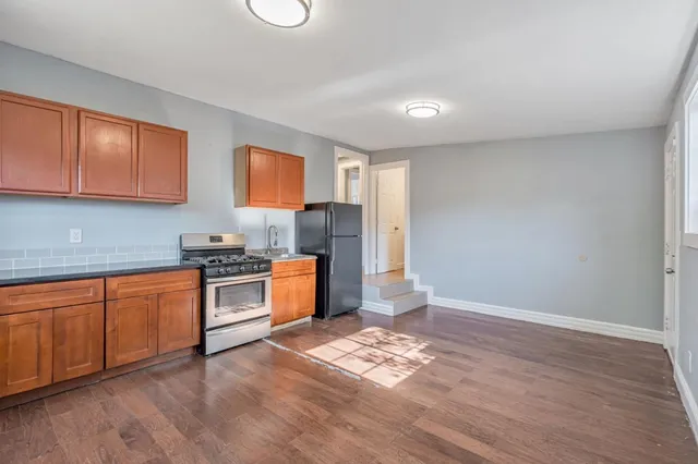 a kitchen with stainless steel appliances granite countertop a stove a sink and a refrigerator