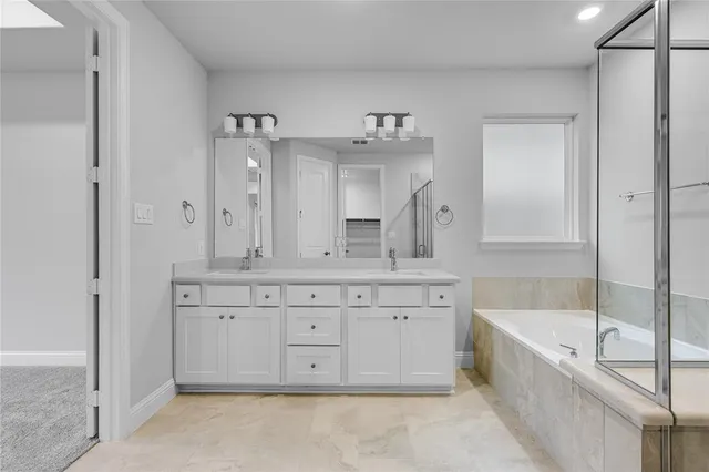a spacious bathroom with a tub sink and mirror