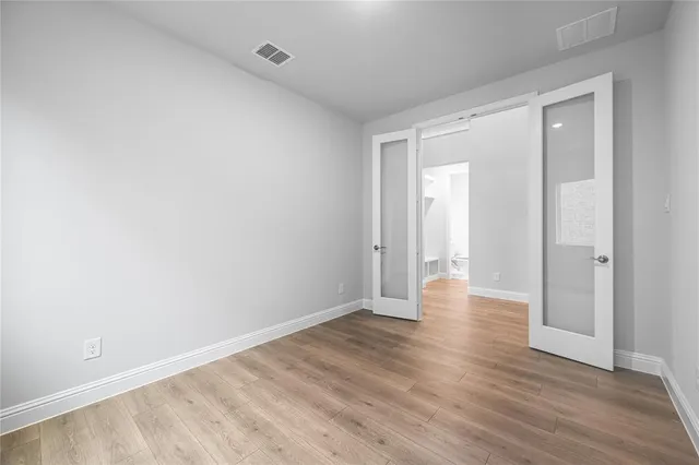 a view of an empty room with wooden floor