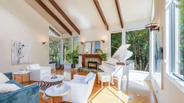 a living room with fireplace furniture large window and a fireplace